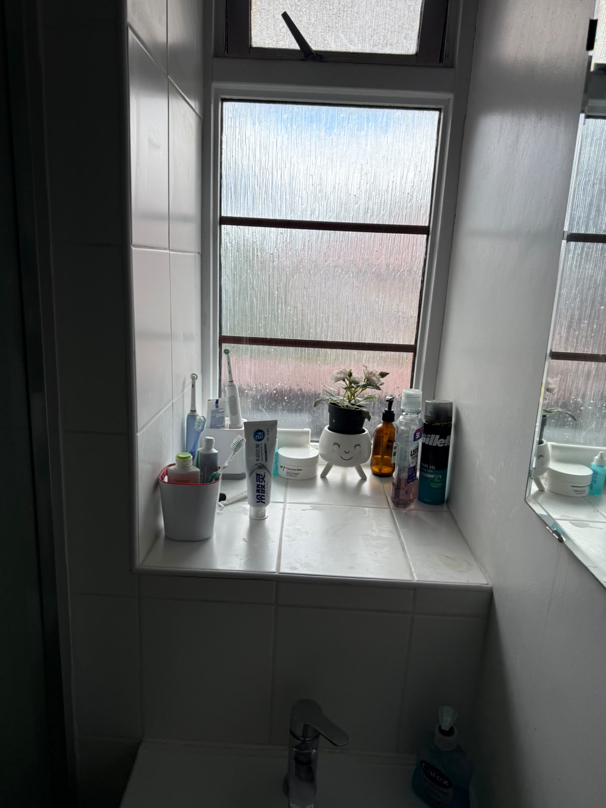 White tiled bathroom walls around a frosted window