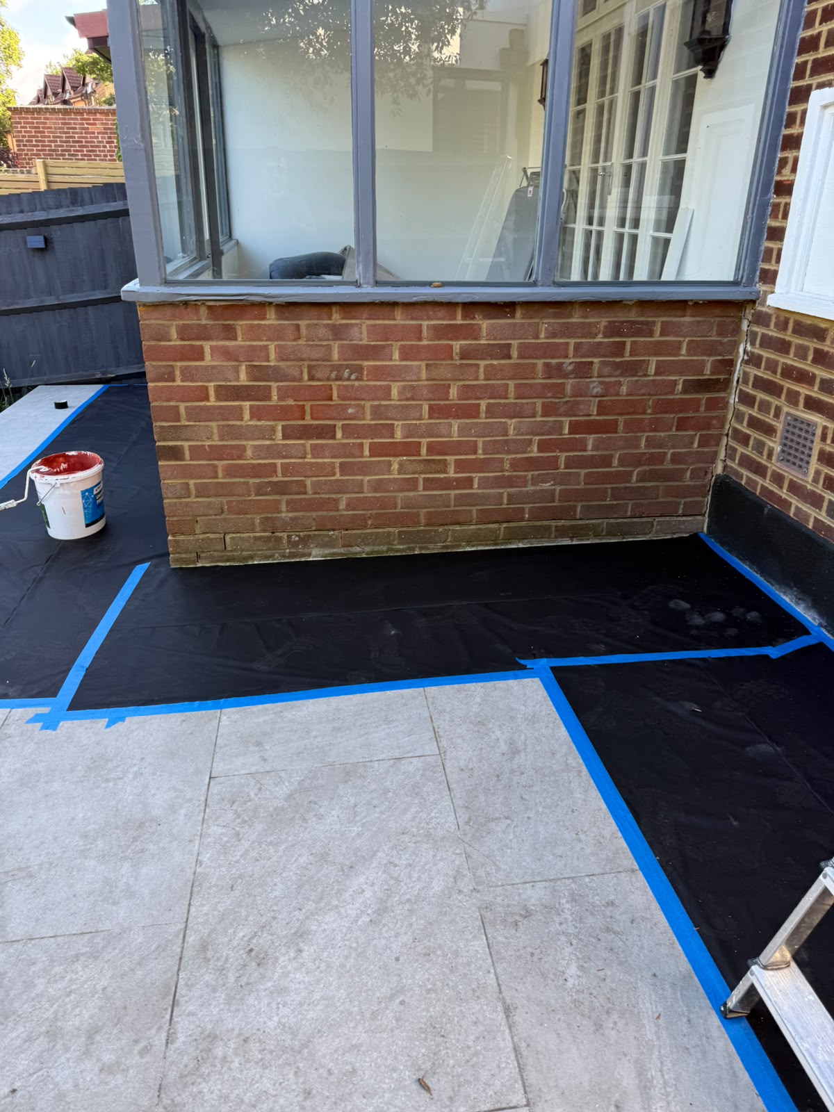 Brick extension corner with protective sheeting during external works